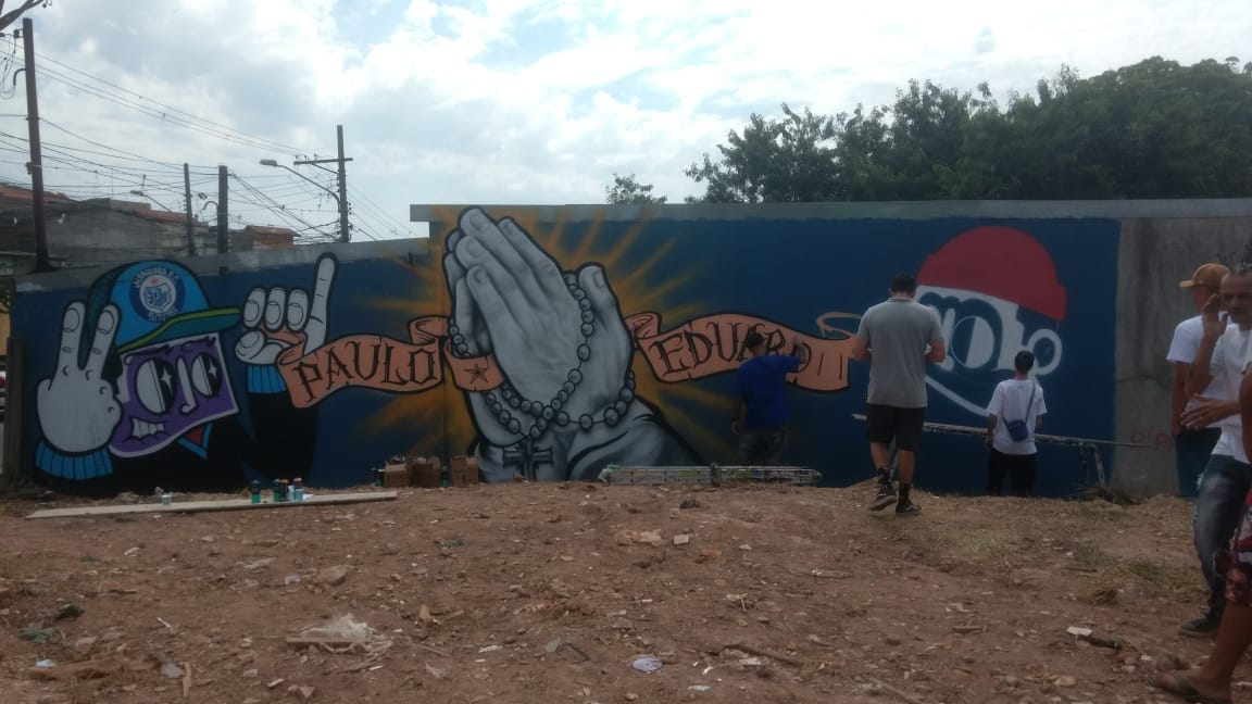 Grafite de mão juntas com um terço e uma faixa escrito no nome Paulo Eduardo